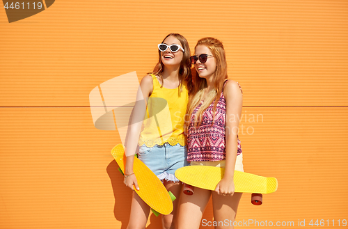 Image of teenage girls with short skateboards outdoors