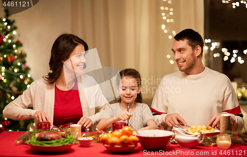 Image of happy family having christmas dinner at home