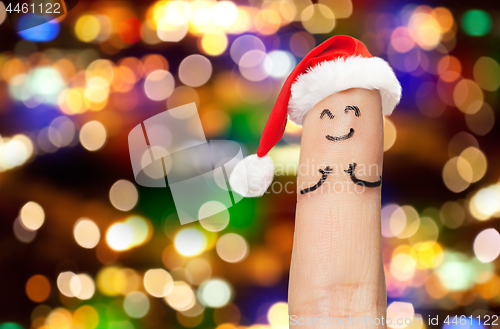 Image of close up of finger in santa hat over lights