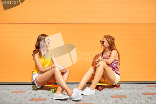 Image of teenage girls with short skateboards in city