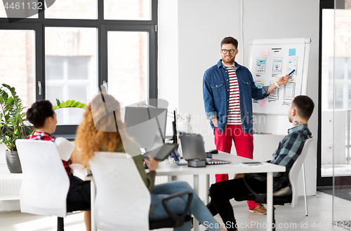 Image of creative man showing user interface at office