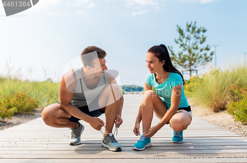 Image of couple of joggers tying sneakers shoelaces