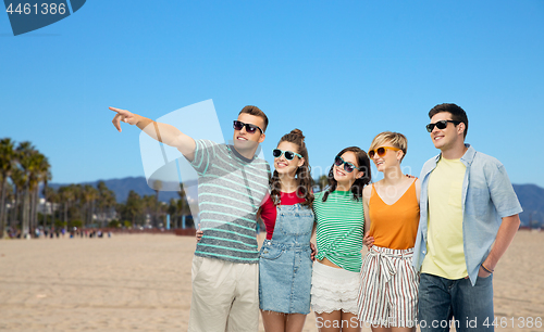 Image of happy friends in sunglasses over venice beach