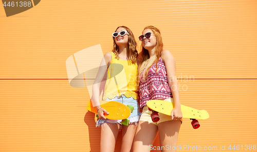 Image of teenage girls with short skateboards outdoors