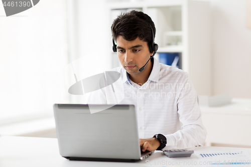 Image of businessman with headset and laptop at office