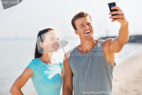 Image of couple taking selfie by smartphone on beach