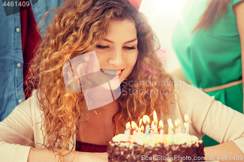 Image of happy woman with candles on birthday cake at party