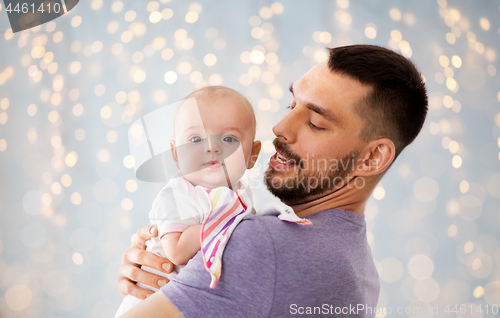 Image of father with little baby girl over festive lights