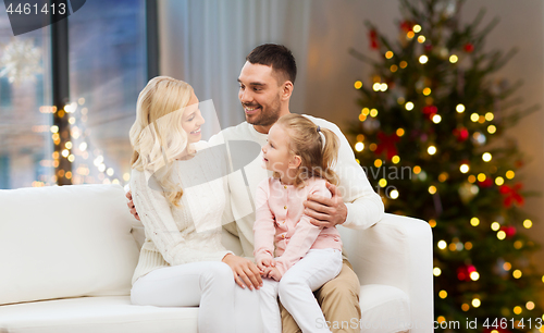 Image of happy family at home over christmas tree lights