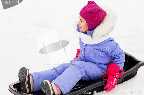 Image of happy little girl on sled outdoors in winter