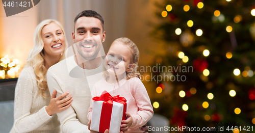 Image of happy family at home with christmas gift