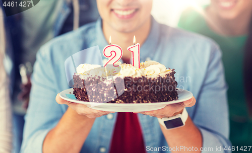 Image of man with cake and friends at birthday party