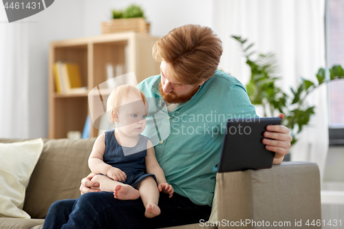 Image of father and baby daughter with tablet pc at home