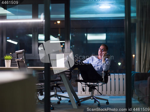 Image of businessman using mobile phone in dark office