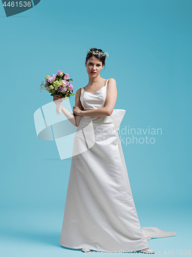 Image of beautiful woman wearing wedding dress against cyan background