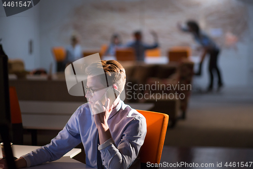 Image of man using mobile phone in dark office