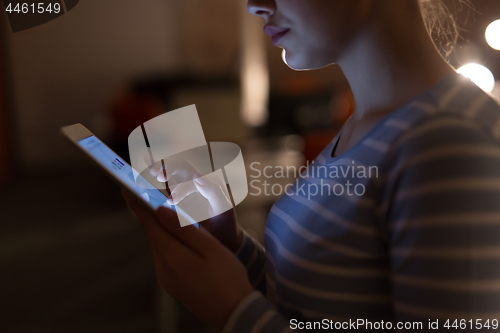 Image of woman working on digital tablet in night office