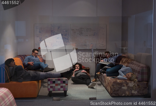 Image of software developers sleeping on sofa in creative startup office