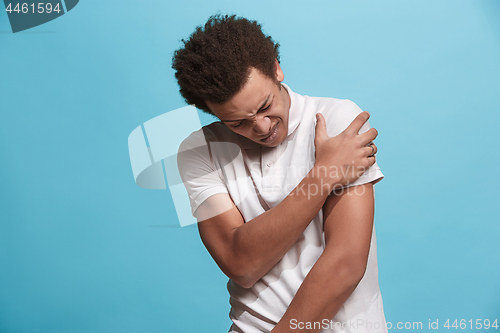 Image of Young man overwhelmed with a pain in the shoulder.