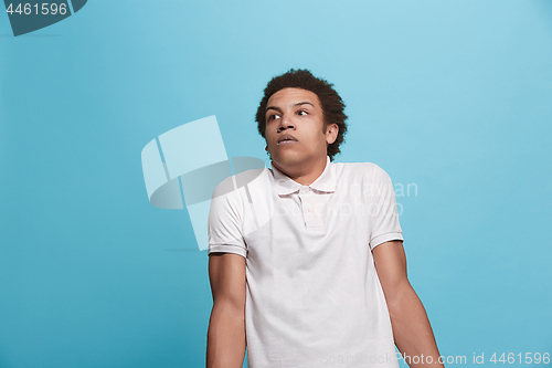 Image of Let me think. Doubtful pensive man with thoughtful expression making choice against blue background