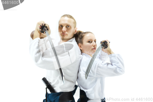 Image of Man and woman fighting and training aikido on white studio background