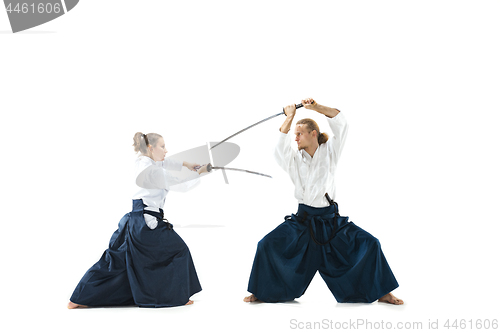 Image of Man and woman fighting and training aikido on white studio background