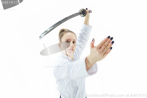 Image of Aikido master practices defense posture. Healthy lifestyle and sports concept. Woman in white kimono on white background.