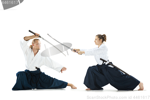 Image of Man and woman fighting and training aikido on white studio background