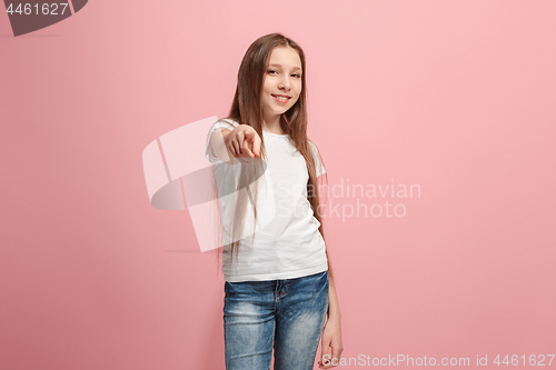 Image of The happy teen girl pointing to you, half length closeup portrait on pink background.