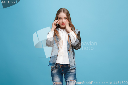 Image of Beautiful teen girl looking suprised isolated on blue