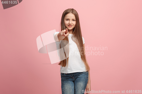 Image of The happy teen girl pointing to you, half length closeup portrait on pink background.