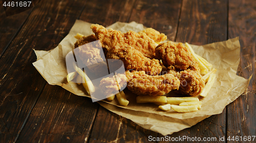 Image of French fries and chicken wings on parchment