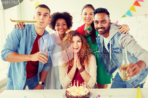 Image of happy coworkers with cake at office birthday party