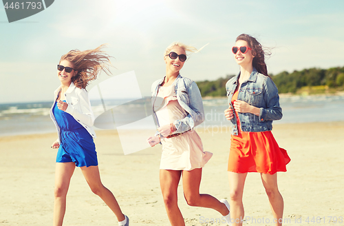 Image of group of smiling women in sunglasses on beach