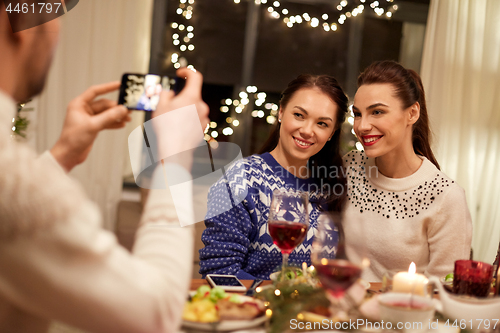 Image of friends having christmas dinner and taking picture