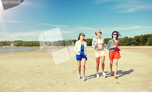 Image of group of smiling women in sunglasses on beach