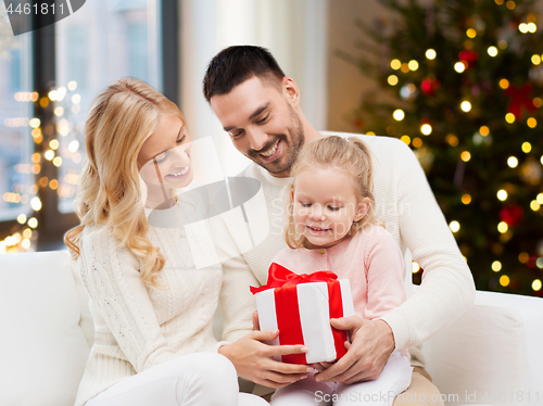 Image of happy family at home with christmas gift