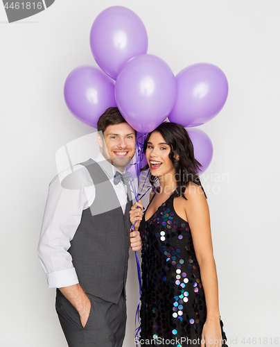 Image of happy couple with ultra violet balloons at party