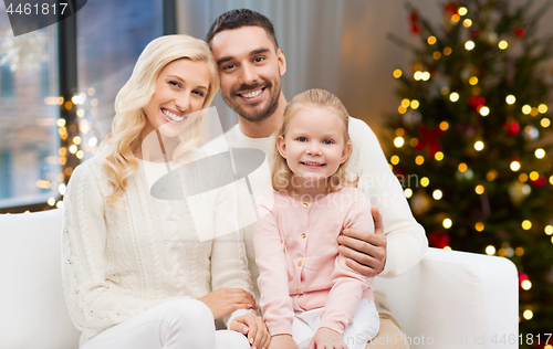 Image of happy family at home over christmas tree lights