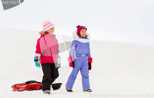 Image of happy little girls with sleds walking in winter