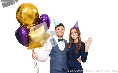 Image of happy couple with party caps and balloons