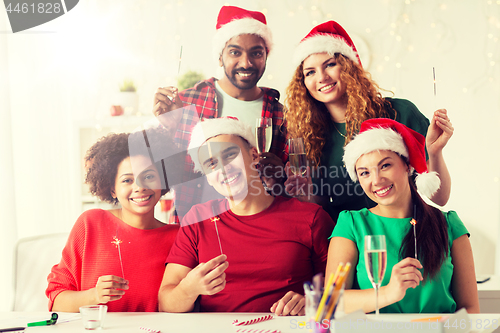 Image of happy team celebrating christmas at office party