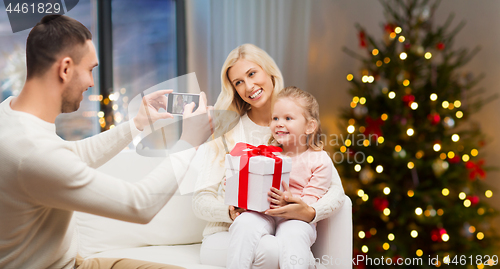 Image of man taking picture of his family on christmas