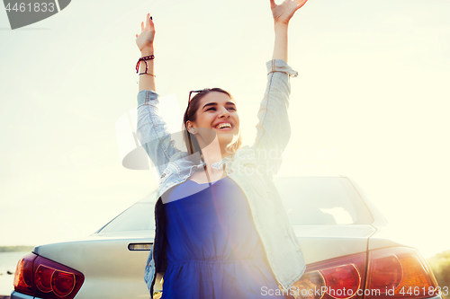 Image of happy teenage girl or young woman near car