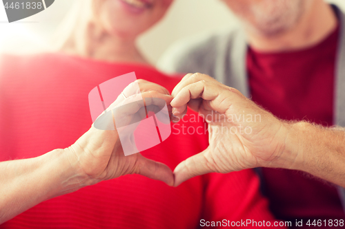 Image of close up of senior couple showing hand heart sign