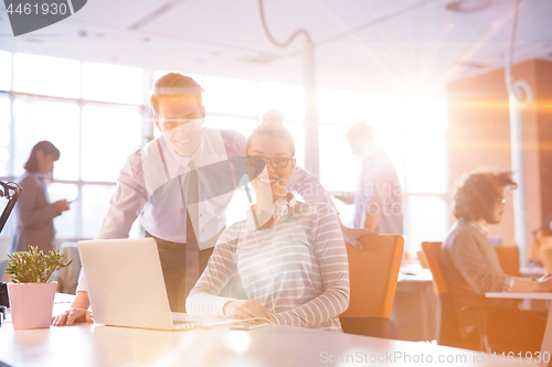 Image of Young businessman helping his colleague at the work