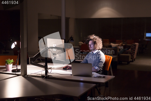 Image of man working on computer in dark office