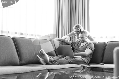 Image of couple using laptop at home