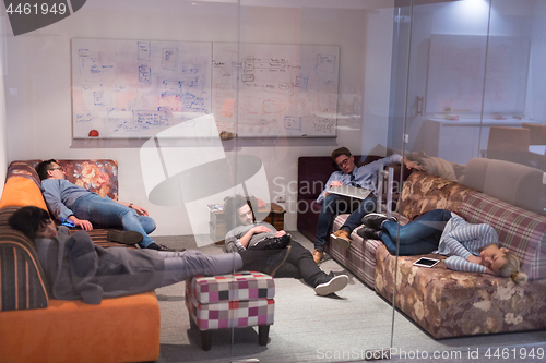 Image of software developers sleeping on sofa in creative startup office