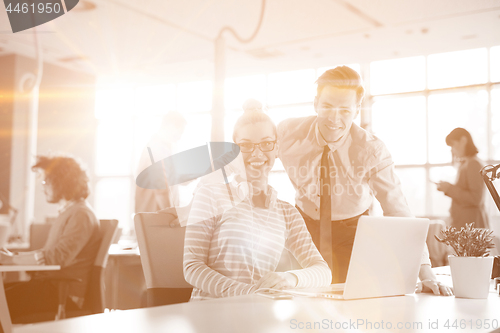 Image of Young businessman helping his colleague at the work